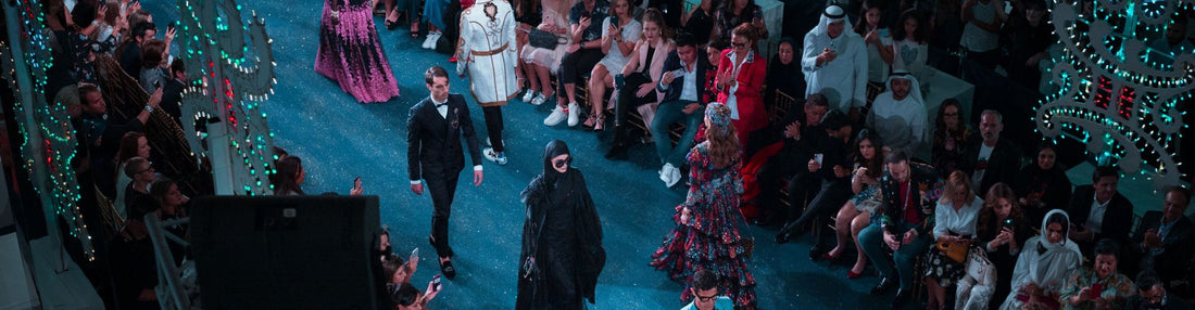 fashion runway with multiple models and a crowd