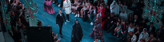fashion runway with multiple models and a crowd