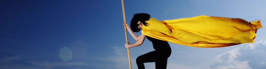 woman planting a flag wearing a superhero cape